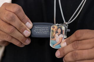 Jerry Mata holds dog tag necklaces of his daughter Tess in front of the Spring Street Courthouse in Los Angeles.