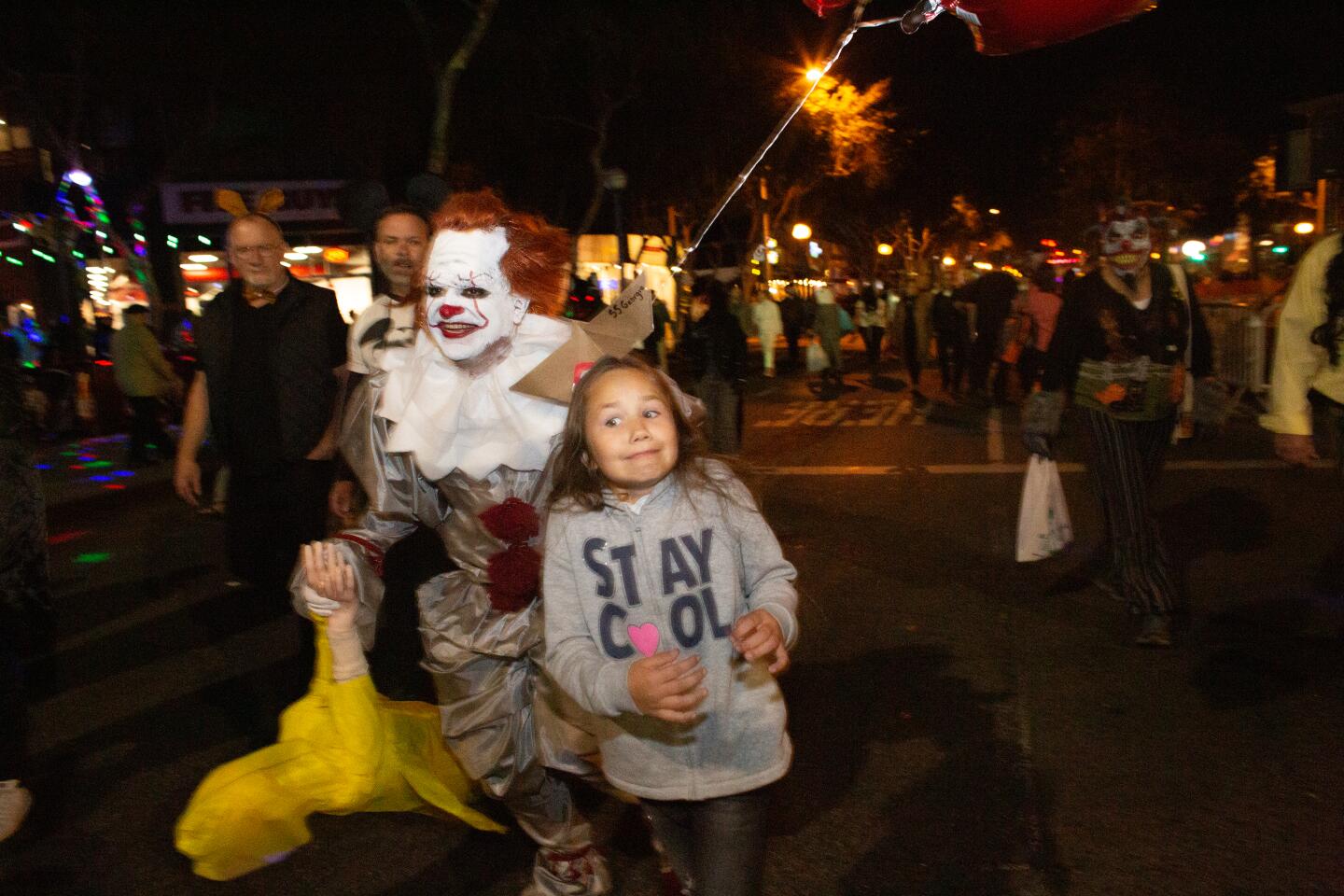 Pennywise begins to run away after sneaking up on a little girl and giving her a scare at the 2019 West Hollywood Carnaval.