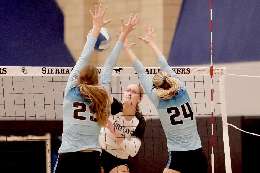 Sierra Canyon hitter Danica Rach gets blocked by Marymount duo Elle Vandeweghe and Lucy Bloom.