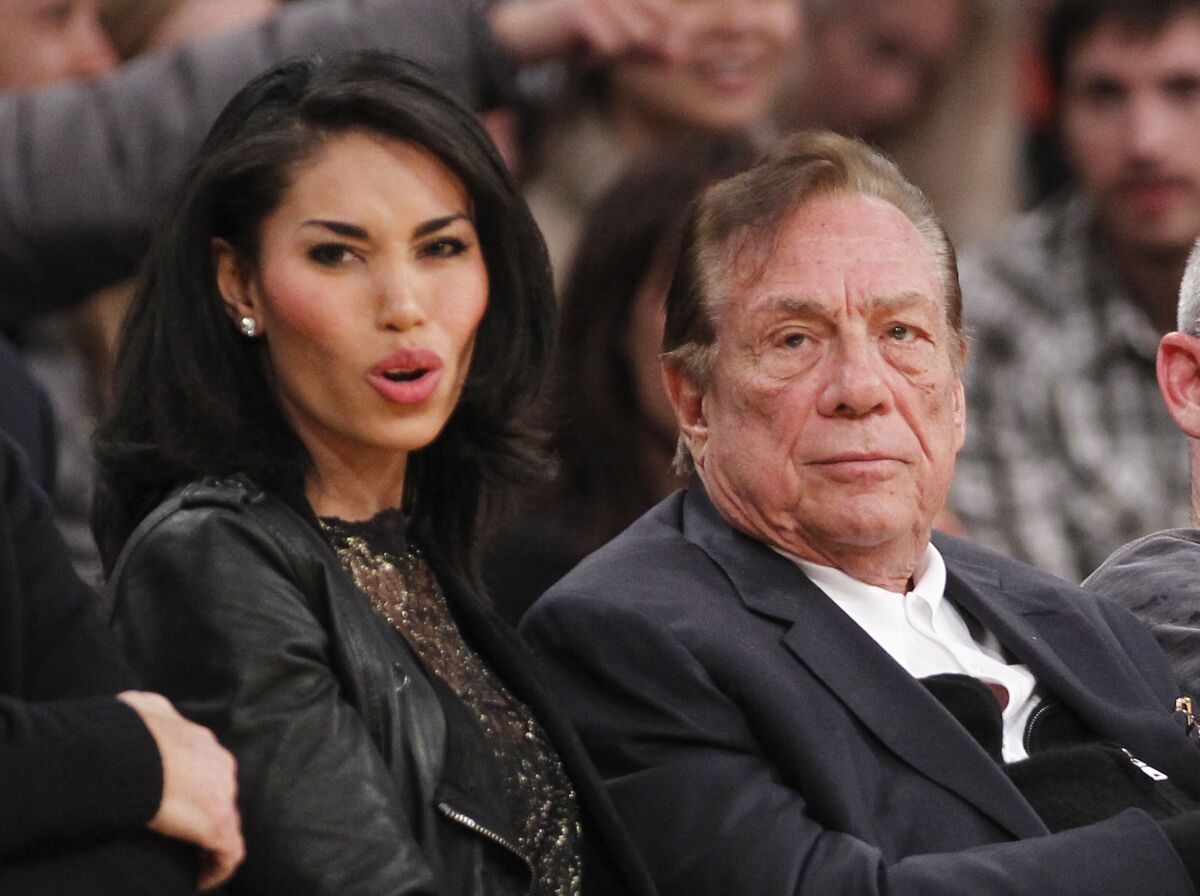 Then-L.A. Clippers owner Donald Sterling and V. Stiviano watch the Clippers play the Lakers during an NBA preseason game in 2010