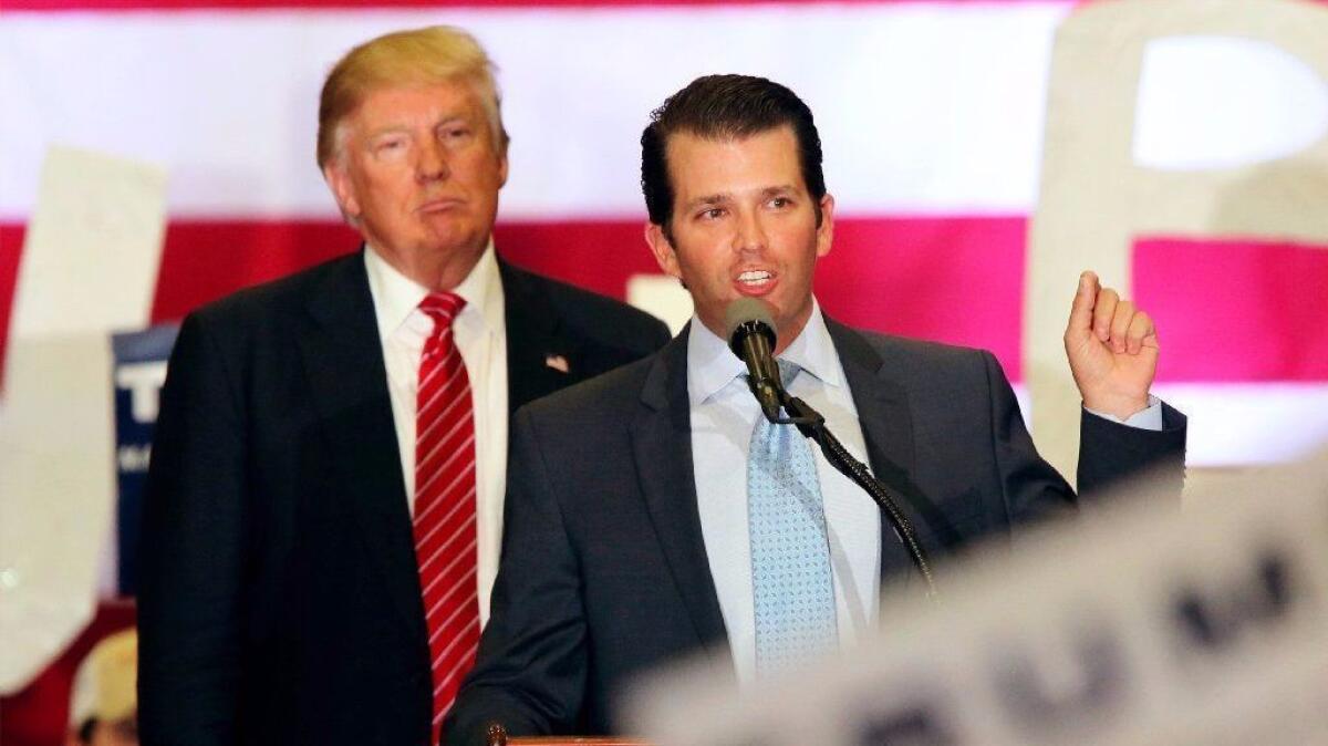 Then-candidate Donald J. Trump listens as his son, Donald Trump Jr., speaks to supporters during a campaign rally in New Orleans on March 4, 2017.