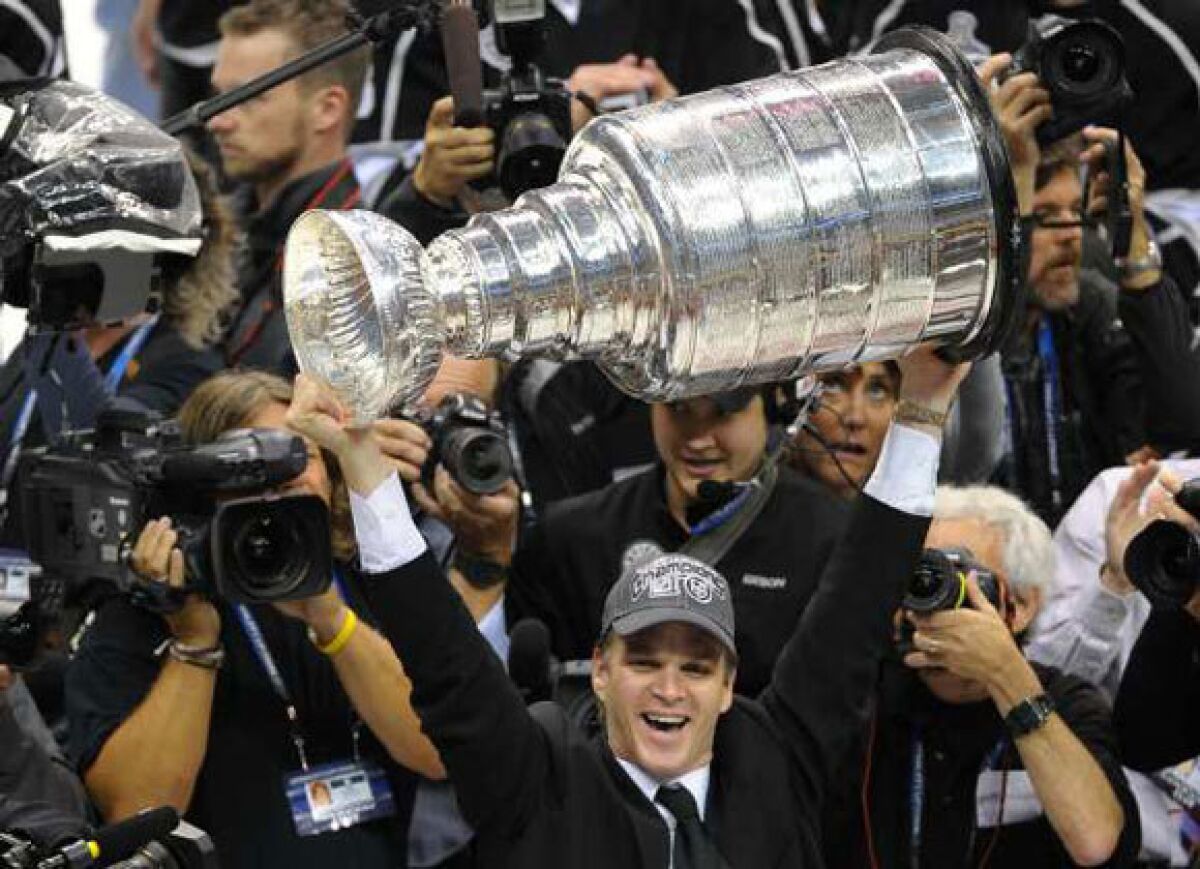Luc Robitaille hoists the Stanley Cup after the Kings' Game 6 victory Monday.
