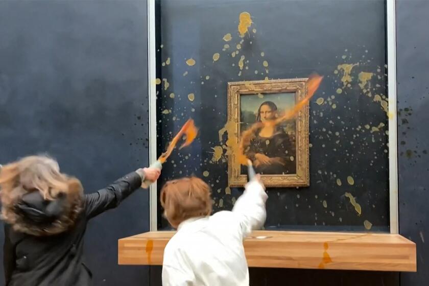 TOPSHOT - This image grab taken from AFPTV footage shows two environmental activists from the collective dubbed "Riposte Alimentaire" (Food Retaliation) hurling soup at Leonardo Da Vinci's "Mona Lisa" (La Joconde) painting, at the Louvre museum in Paris, on January 28, 2024. Two protesters on January 28, 2024 hurled soup at the bullet-proof glass protecting Leonardo da Vinci's "Mona Lisa" in Paris, demanding the right to "healthy and sustainable food", an AFP journalist said. It is the latest attack on the masterpiece in the French capital's Louvre museum, after someone threw a custard pie at it in May 2022, but it's thick glass casing ensured it came to no harm. (Photo by David CANTINIAUX / AFPTV / AFP) (Photo by DAVID CANTINIAUX/AFPTV/AFP via Getty Images)