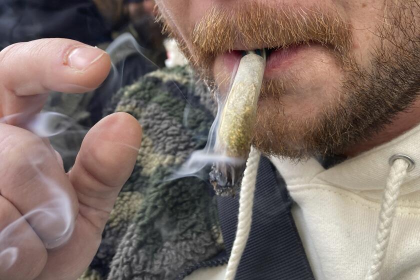 ARCHIVO - Un hombre fuma marihuana en Lower Manhattan afuera del primer dispensario legal de marihuana recreativa en Nueva York el jueves 29 de diciembre de 2022. (AP Foto/Ted Shaffrey, Archivo)