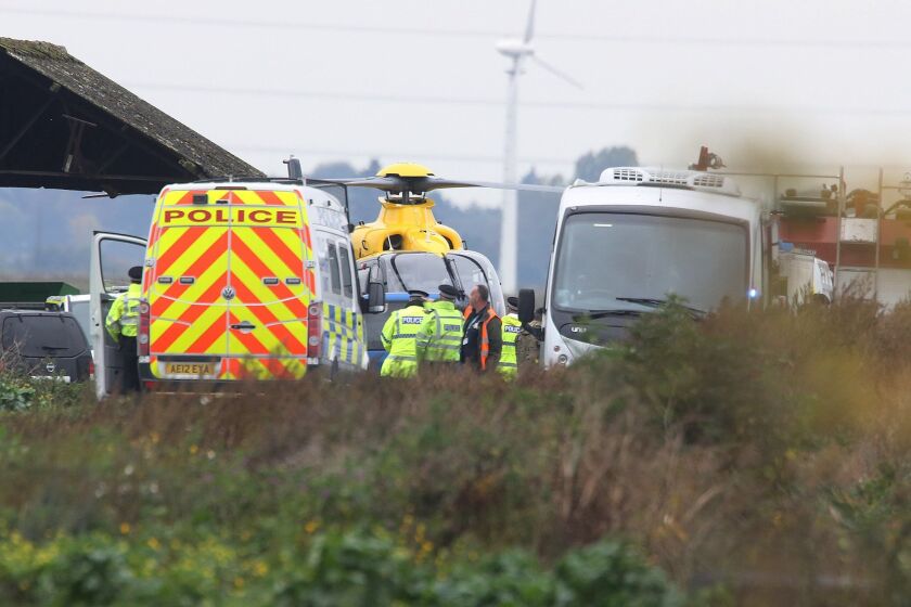 Police gather near the scene of a jet crash Oct. 21 in Redmere, England.