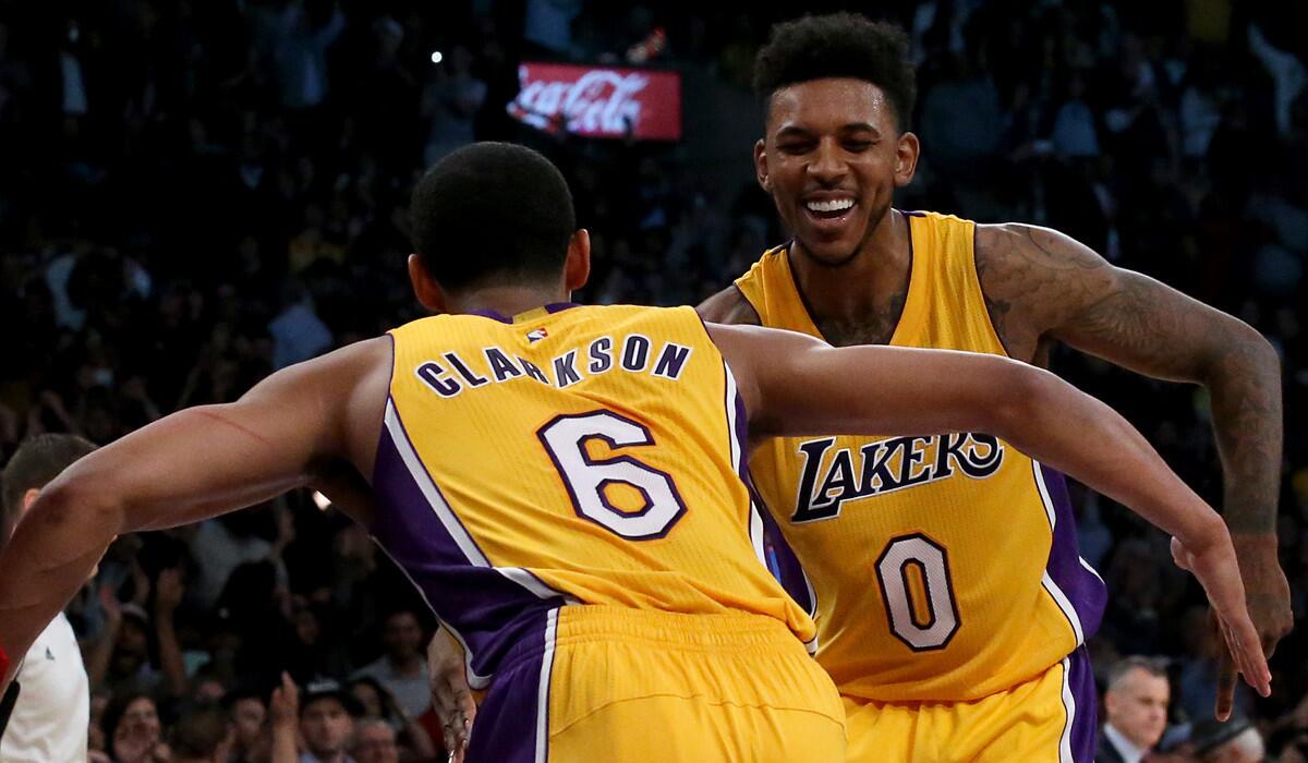 Lakers' Nick Young (0) and Jordan Clarkson (6) celebrate a three-pointer by Young that sealed a 111-109 victory over the Thunder on Tuesday at Staples.