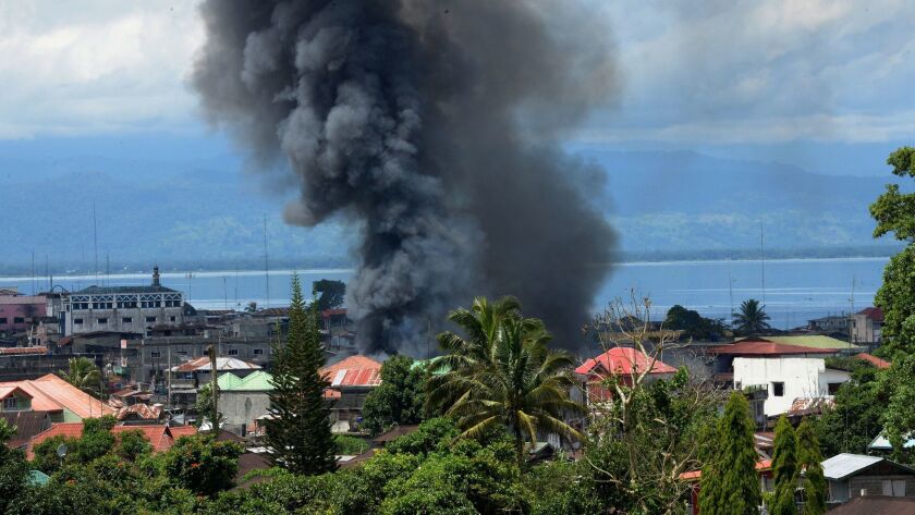 Smoke billows from houses after a government airstrike on Islamic militants' position in Marawi, on the southern Philippine island of Mindanao, on May 27, 2017.