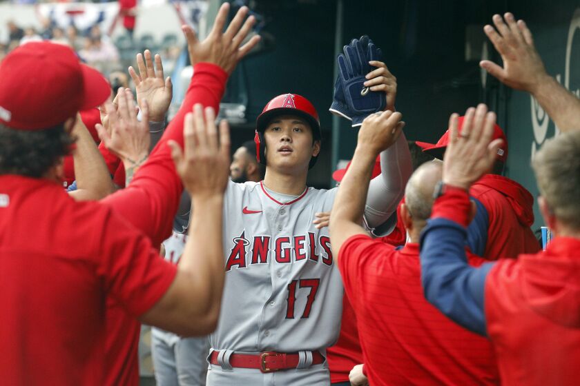 Los Angeles Angels designated hitter Shohei Ohtani (17) is greeted in the dugout after scoring.