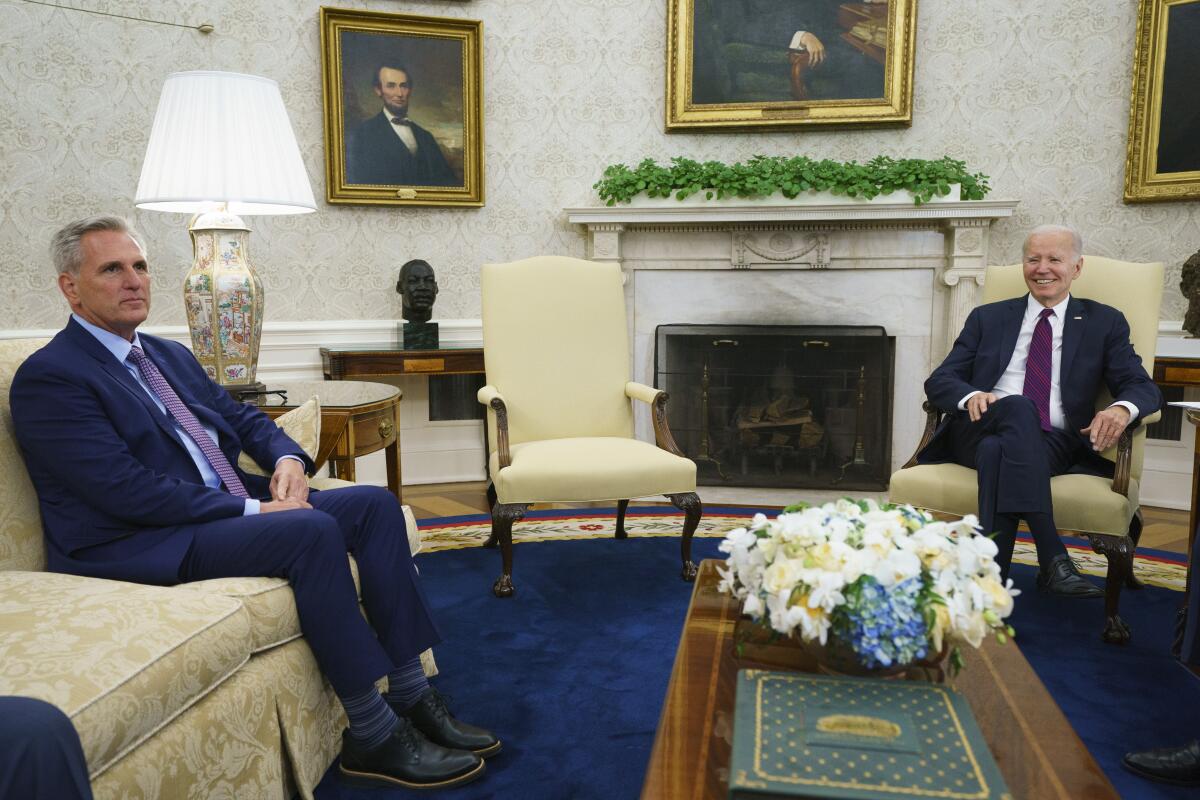 House Speaker Kevin McCarthy and President Biden seated in the Oval Office.