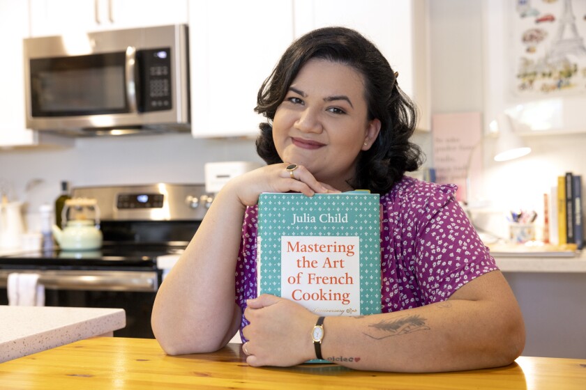 Oceanside resident Jaíne Mackievicz-Cenci with the Julia Child cookbook she used to learn how to cook.