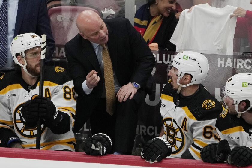 FILE - Boston Bruins head coach Jim Montgomery speaks to left wing Brad Marchand (63) during the first period of Game 4 of an NHL hockey Stanley Cup first-round playoff series, Sunday, April 23, 2023, in Sunrise, Fla. (AP Photo/Marta Lavandier, File)