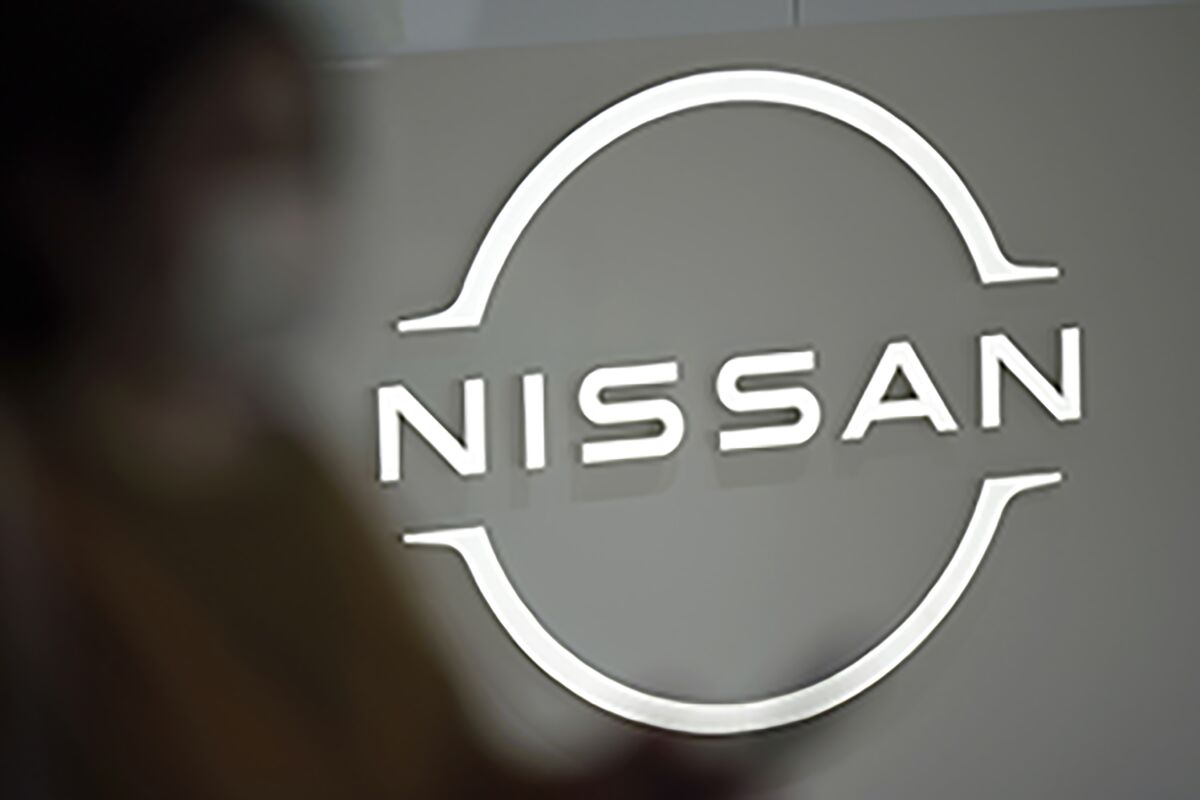 FILE - A visitor walks near a Nissan logo at Nissan headquarters on May 12, 2022, in Yokohama near Tokyo. Nissan is considering adding a new auto plant in the U.S. to keep up with growing demand for electric vehicles, a top executive at the Japanese automaker said Friday, May 13, 2022. (AP Photo/Eugene Hoshiko, File)