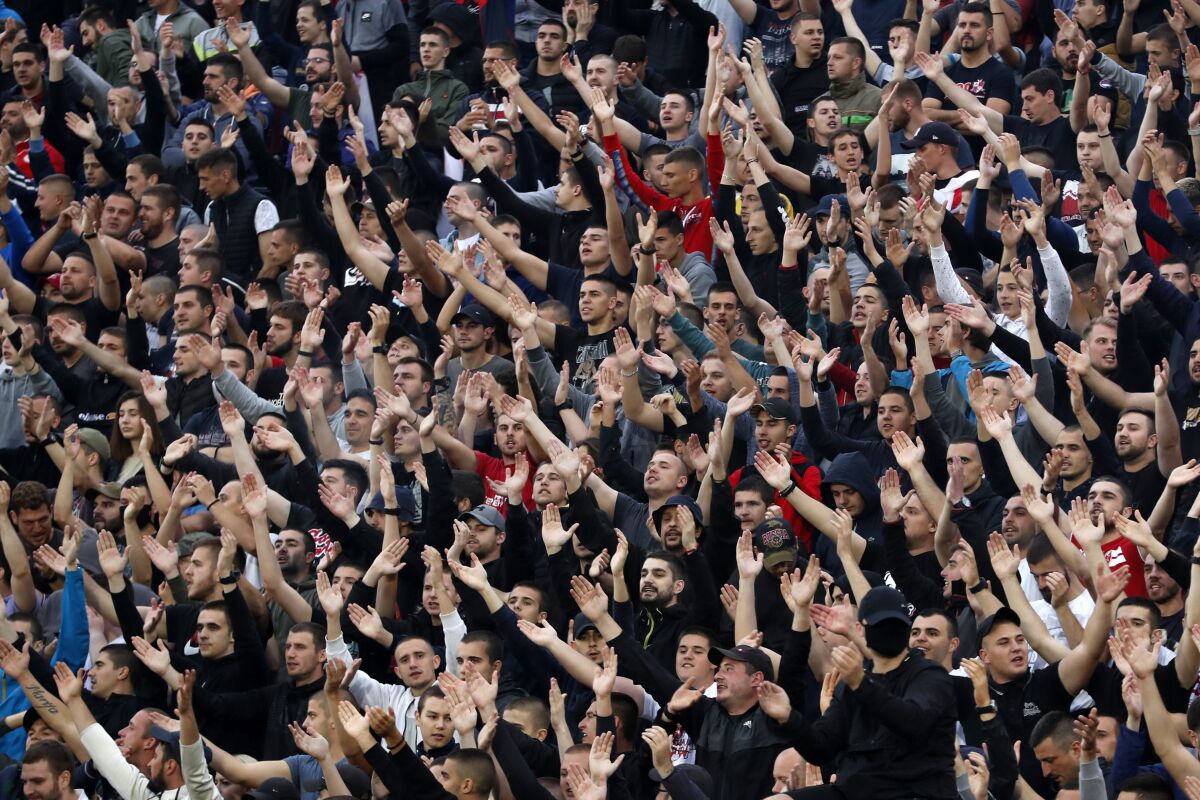 In this Wednesday, June 10, 2020. photo, Red Star fans support their team during a Serbian National Cup semi final soccer match between Partizan and Red Star in Belgrade, Serbia. Red Star Belgrade soccer club director Zvezdan Terzic says he has tested positive for the coronavirus, days after the Serbian champions played matches in front of thousands of fans despite the pandemic. (AP Photo/Darko Vojinovic)