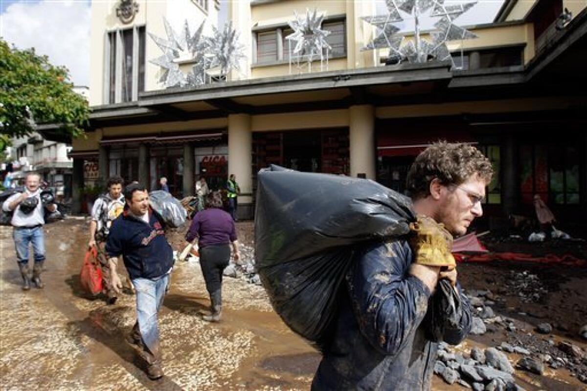 People salvage from the market of Funchal, the Madeira Island's capital, Sunday, Feb. 21, 2010. Rocks and mud were brought down from the hills to the streets of Funchal by flash floods on Saturday and the local government confirmed many dead. (AP Photo/Armando Franca)