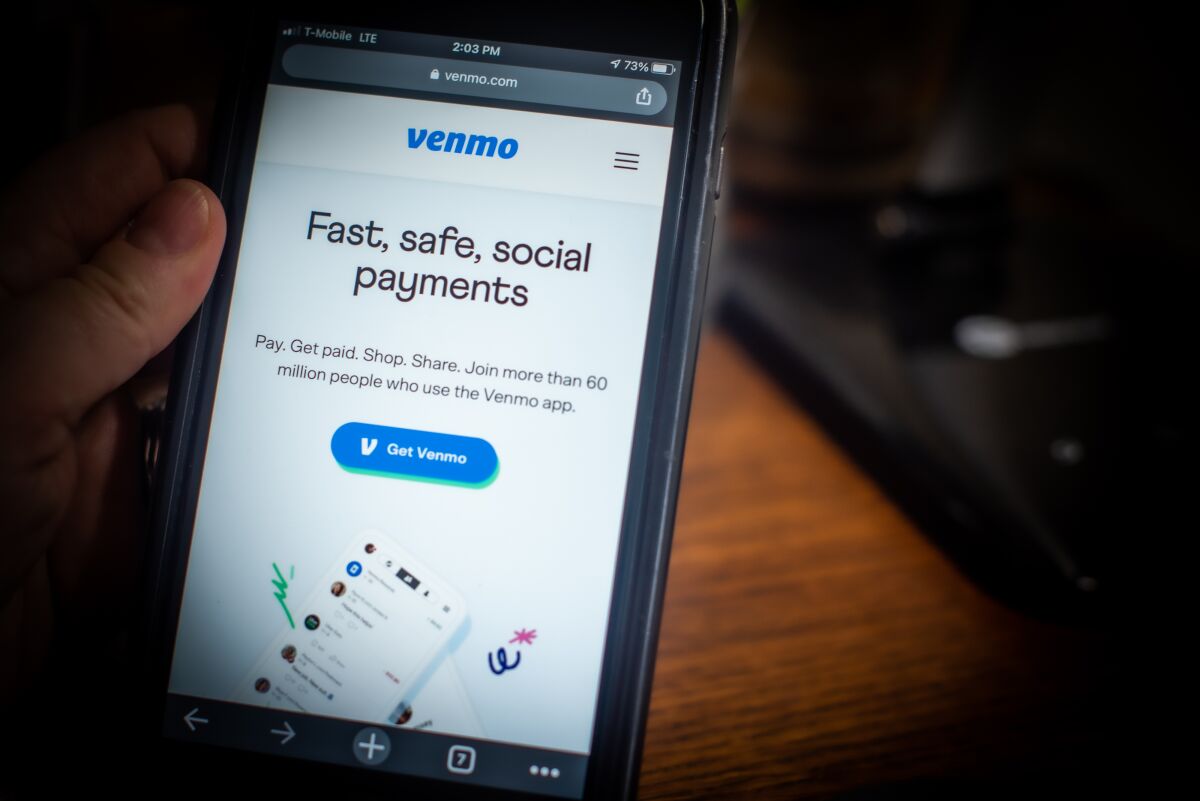A hand holding a smartphone with the Venmo app open