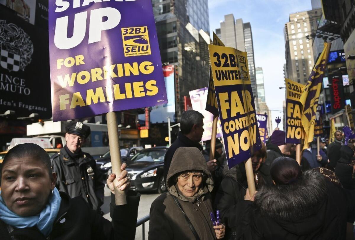 Cleaners, porters and matrons of theater union SEIU Local 32BJ demonstrate outside the Broadway League's office, before a vote authorizing a strike in New York on Dec. 12.
