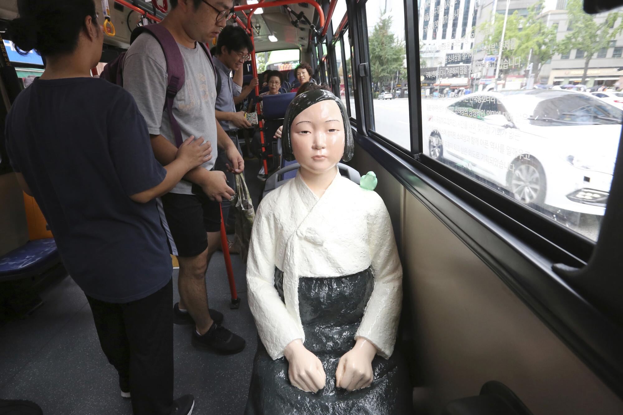 A statue of a "comfort woman" seated on a bus