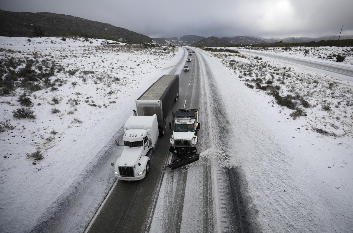 A snowplow clears Interstate 8 at Laguna Summit during a steady snow on Monday.