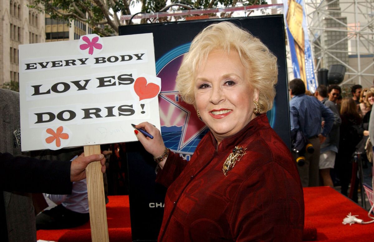 Doris Roberts autographs a sign during the Feb. 10, 2003, ceremony honoring her with a star on Hollywood's Walk of Fame.