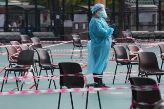 A health worker wearing protective gear waits for residents to be tested for the coronavirus at a temporary testing center in Hong Kong, Monday, Feb. 28, 2022.(AP Photo/Vincent Yu)