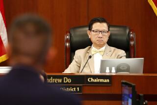 County Supervisor Andrew Do listens as Public Health officer Clayton Chau, left, speaks.