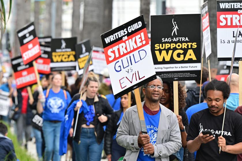 Writers on strike march with signs on the picket line on day four of the strike by the Writers Guild of America in front of Netflix in Hollywood, California on May 5, 2023. - More than 11,000 Hollywood television and movie writers are on their first strike since 2007 after talks with studios and streamers over pay and working conditions failed to clinch a deal. (Photo by Frederic J. BROWN / AFP) (Photo by FREDERIC J. BROWN/AFP via Getty Images)