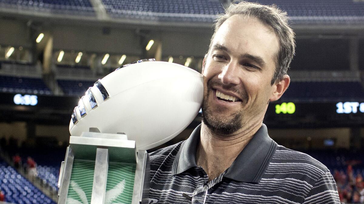 Tyson Helton holds the Peach Bowl trophy after helping guide Western Kentucky to a 45-35 win over South Florida on Dec. 21.