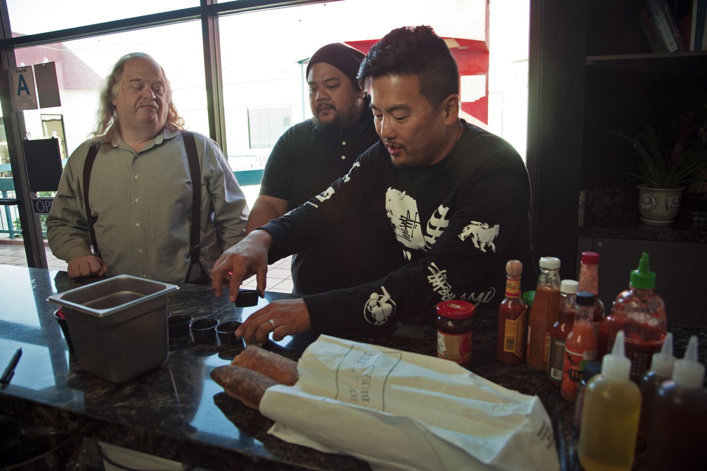 Jonathan Gold, left, chef Alvin Cailan of Eggslut and Ramen Champ, and chef Roy Choi of Kogi taste hot sauces to see if they can find a new favorite.