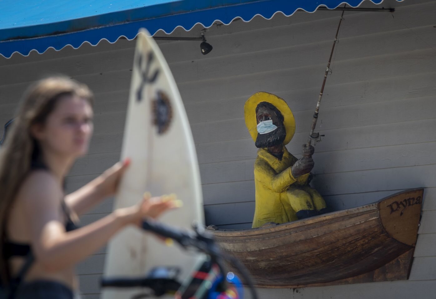 Statue is fitted with a mask on the outside of Fisherman's Restaurant and Bar in San Clemente