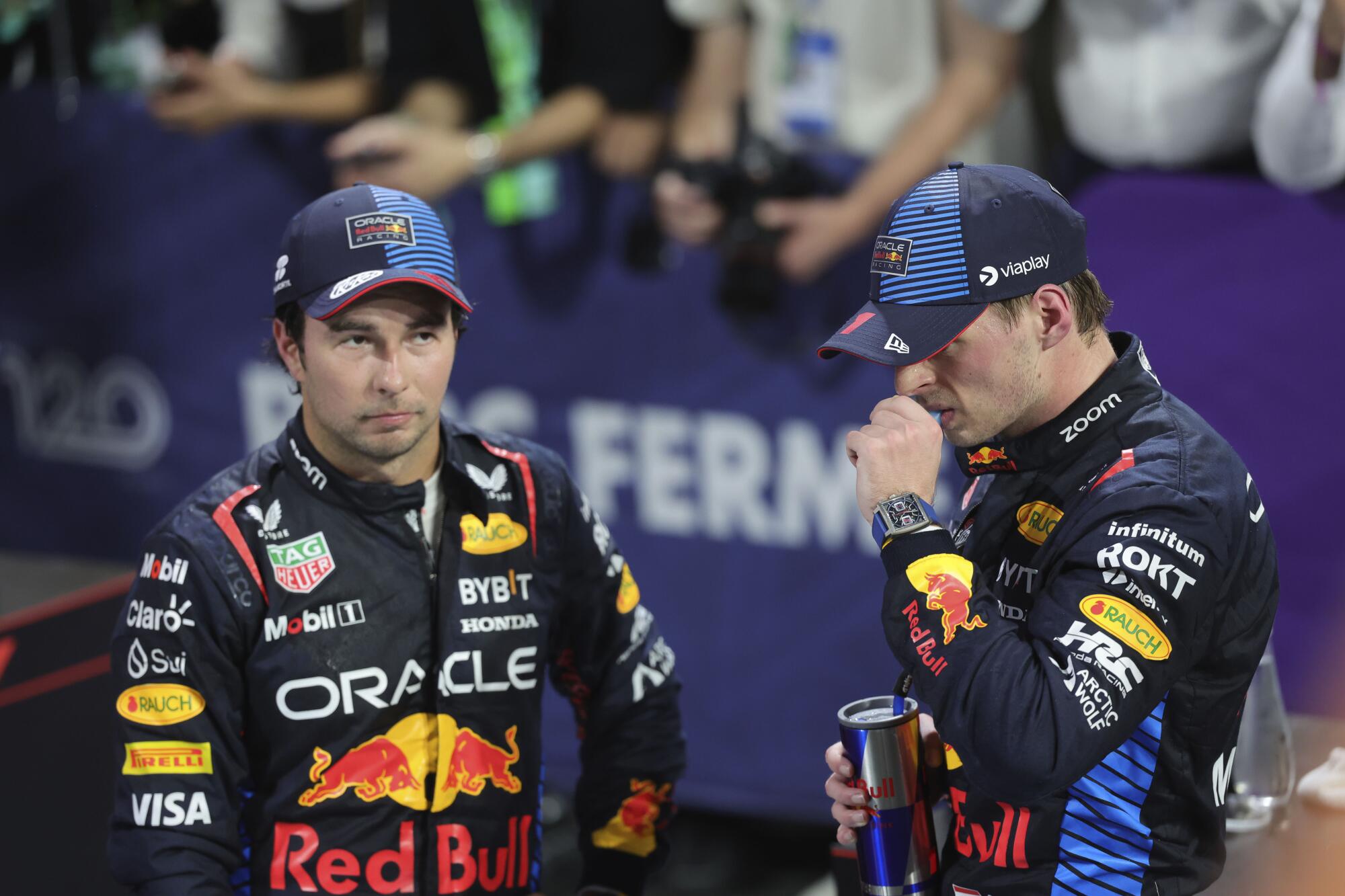 Two Formula One drivers wear racing suits with Oracle and Red Bull logos.