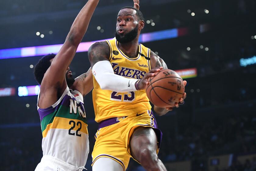 LOS ANGELES, CALIFORNIA FEBUARY 25, 2020-Lakers LeBron James drives past Pelicans Derrick Favors to pass the ball in the 1st quarter at the Staples Center Tuesday. (Wally Skalij/Los Angeles Times)