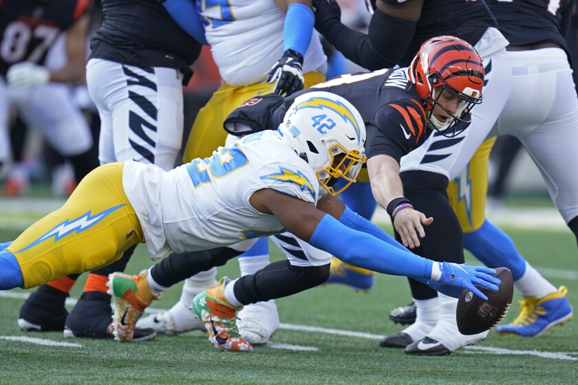 The Chargers' Uchenna Nwosu (42) and the Bengals'  Joe Burrow dive for the quarterback's fumble. Nwosu recovered.
