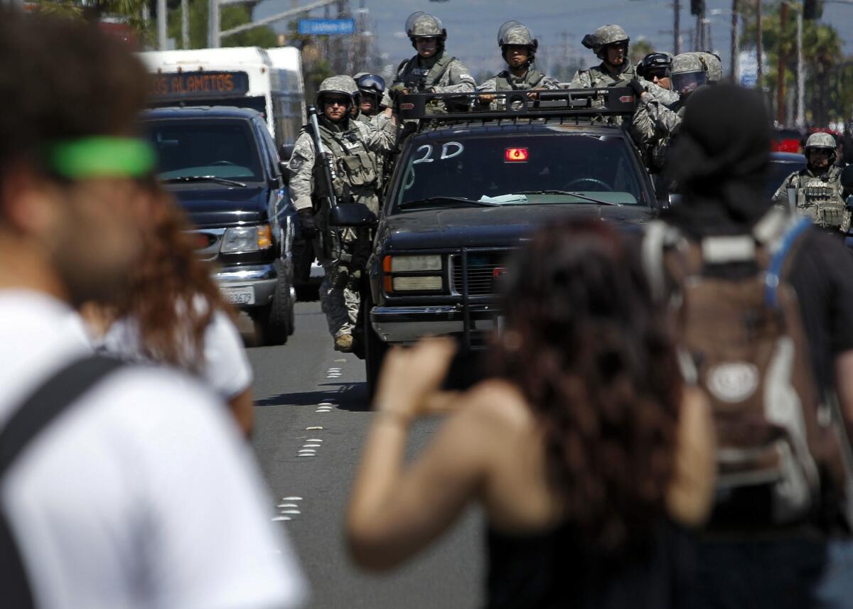 Police in riot gear move through a crowd of protesters in Anaheim in July 2012.