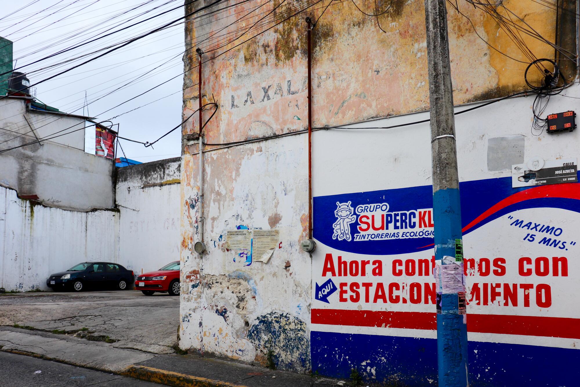 A corner of a building with a faded "xalapeño" sign.