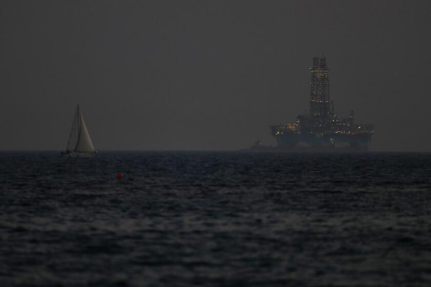 FILE - An offshore drilling rig is seen in the waters off Cyprus' coastal city of Limassol, on July 5, 2020 as a sailboat sails in the foreground. The Cyprus government has given U.S. energy company Chevron another six months to come up with a revised plan to develop a sizeable natural gas deposit off the island nation's southern coastline after an earlier plan was deemed to lack a specific timetable, an official said Thursday, May 2, 2024. (AP Photo/Petros Karadjias, File)