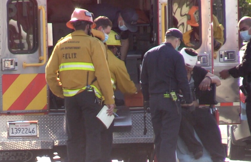 First responders attend to one of three people injured in a stabbing attack in South Los Angeles.