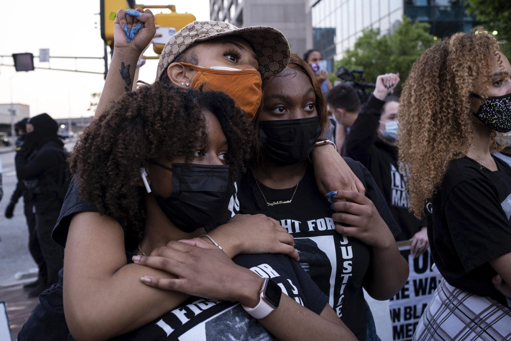 Chiara Campbell, from left, Nyasia Thompson and Jaylah Lesesne embrace following a march through downtown Atlanta.