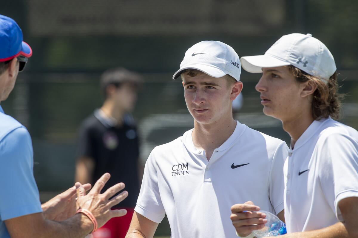Corona del Mar's Jack Knox, center, and Jonathan Hinkel, right, listen to coach Jamie Gresh during a doubles match.