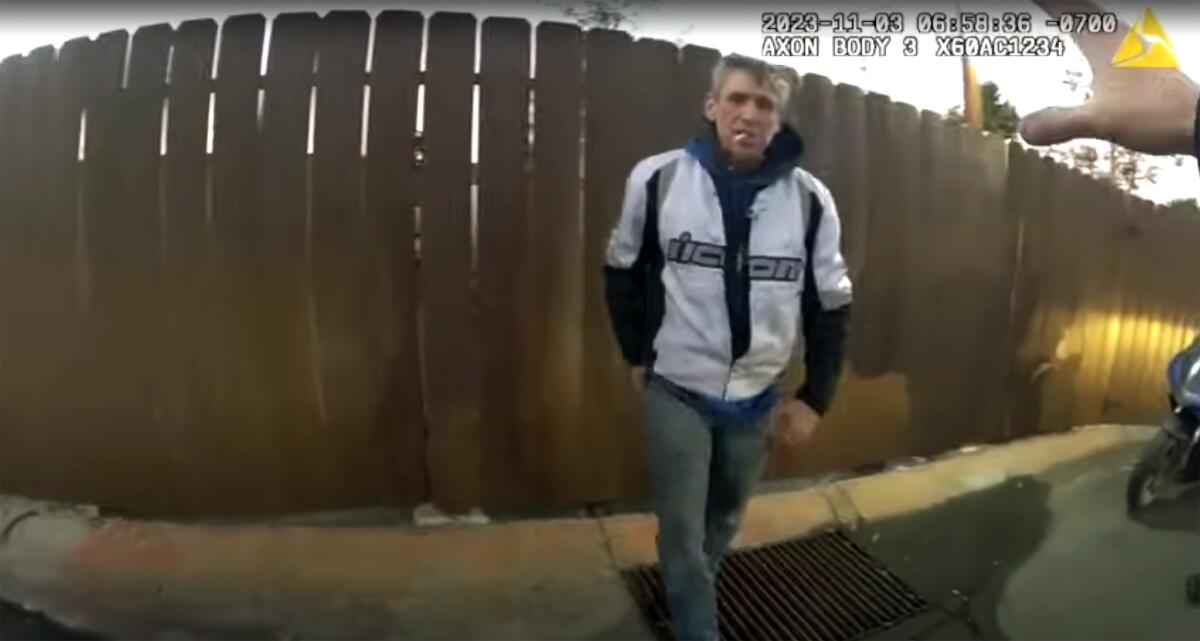 Quinn reaches for a handgun hidden behind his back before two police officers open fire on him.