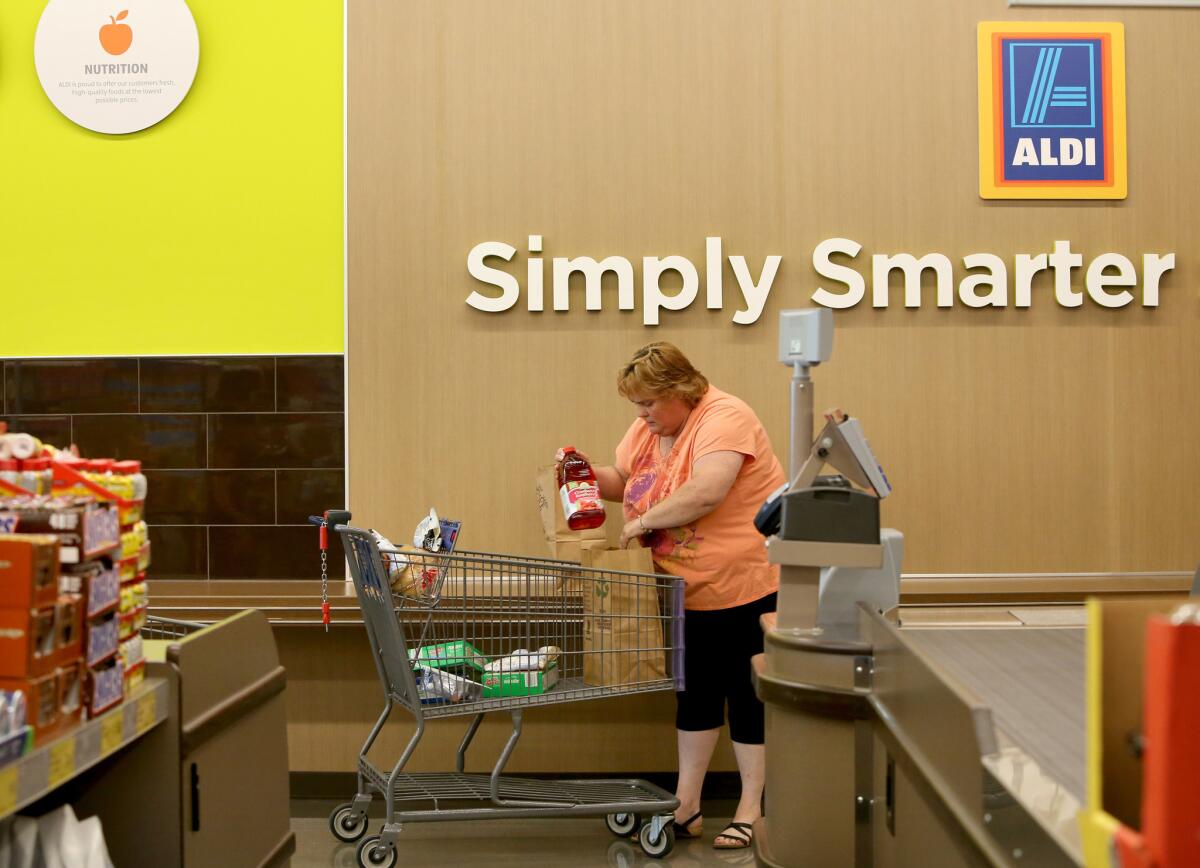 Shopper Patti Gerstenbeger bags her own groceries at the Aldi store in Niles, Ill., on Wednesday, June 10, 2015. Aldi is opening its first eight stores in Southern California on March 24.