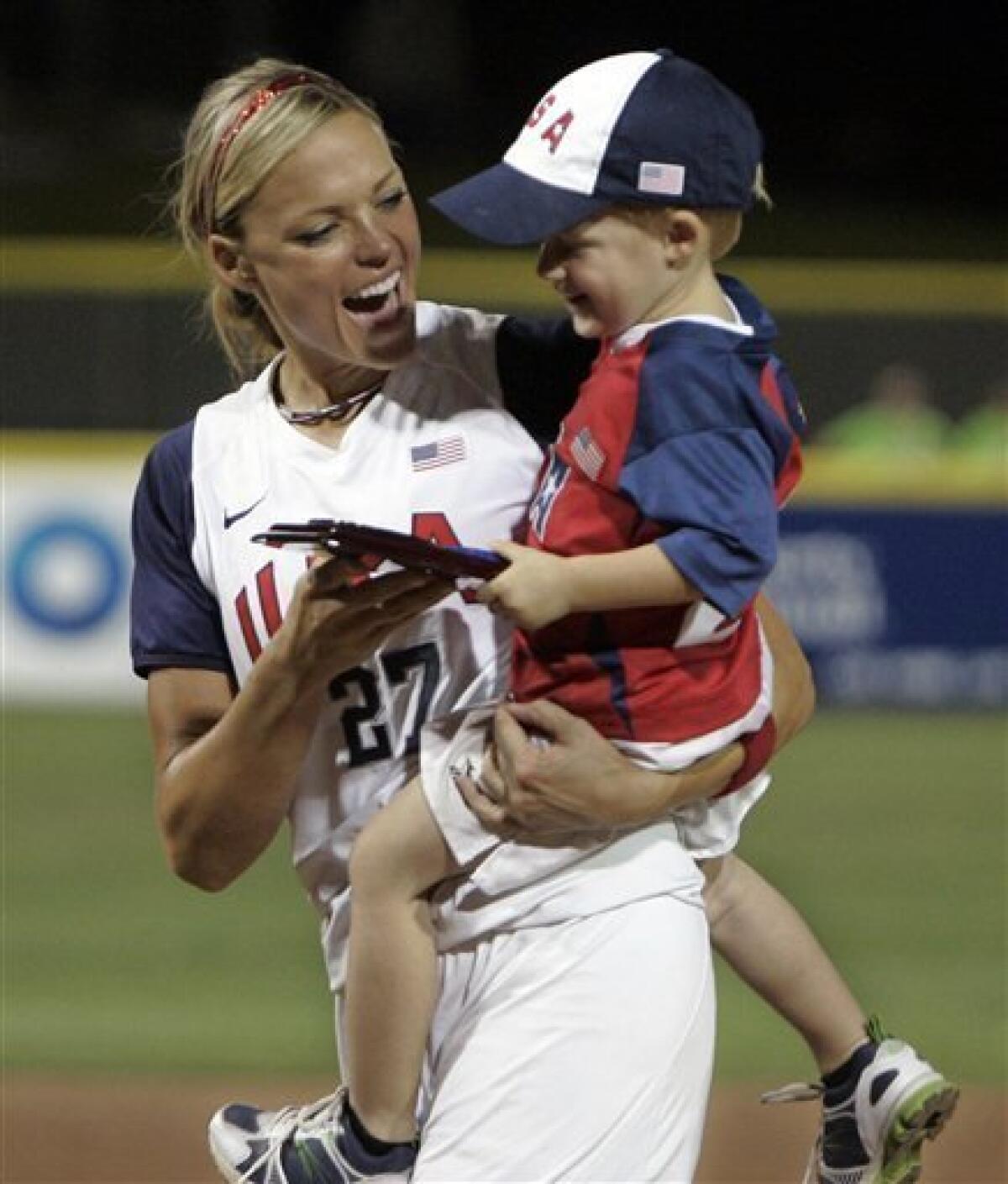 FILE - This July 20, 2009, file photo shows United States' Jennie Finch, left, holding her individual plaque and her son, Ace, following the World Cup of Softball championship game in Oklahoma City. The U.S. defeated Australia 3-1. Olympic gold medalist Jennie Finch plans to retire next month and bring an end to a 10-year career in which she helped the sport blossom in the United States. The dominating pitcher announced Tuesday, July 20, 2010, that she will play her final games with the U.S. national team this week at the World Cup of Softball in Oklahoma City. (AP Photo/File)