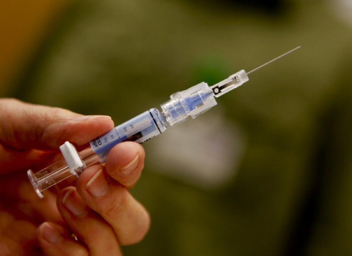A syringe is filled with flu vaccine at a Pasadena clinic.