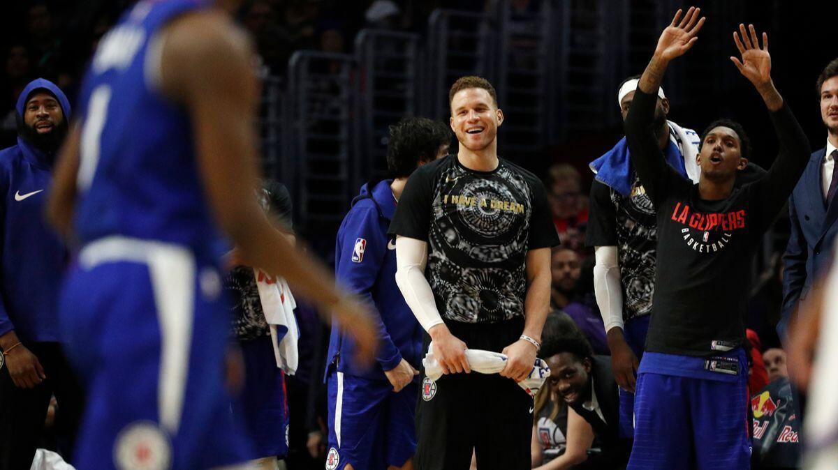 Clippers forward Blake Griffin, middle, and guard Lou Williams, right, cheer on the team in the final moments of the Clippers' win against the Sacramento Kings on Saturday at Staples Center.