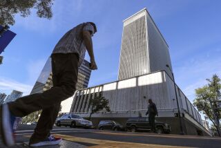 Pedestrians cross A Street with the former Sempra building, located on Ash Street, in the background on Tuesday, December 17, 2019 in San Diego, California.