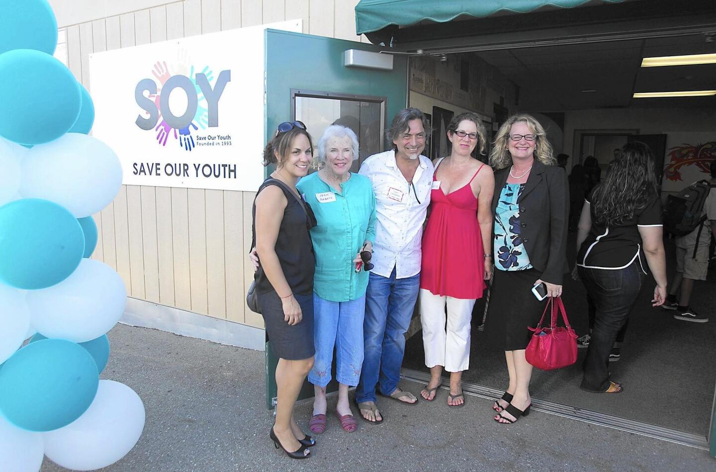 SOY board member Adriana Desmond, Jean Forbath, SOY board member Ivan Calderon, Susie Forbath, and Costa Mesa Councilwoman Katrina Foley gather during the grand opening of the new Save Our Youth center in Costa Mesa on Wednesday.
