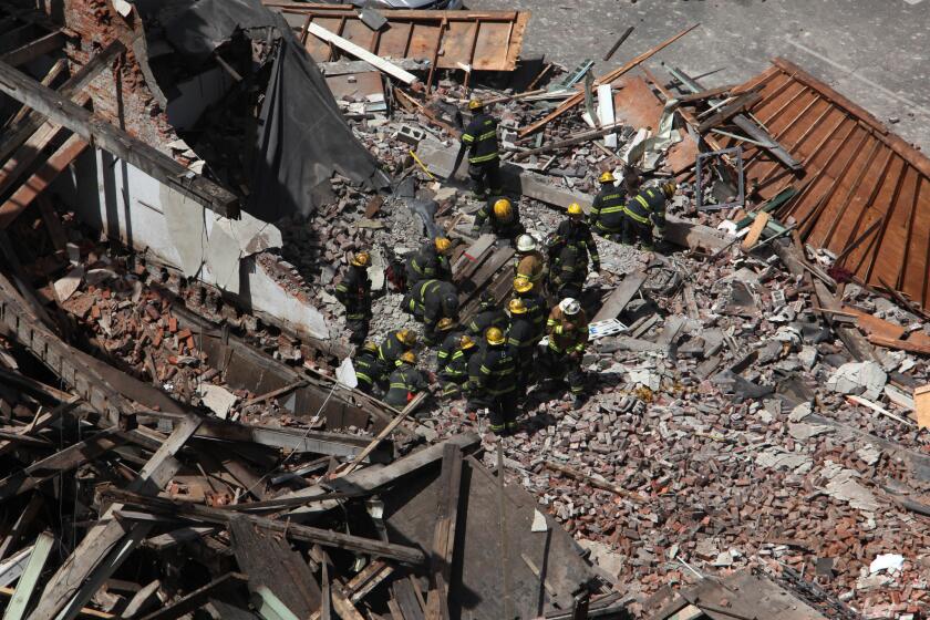 Rescue personnel work at the scene of a collapsed four-story building in downtown Philadelphia on Wednesday. Twelve people were injured and two others are believed trapped beneath the rubble, the fire commissioner said.