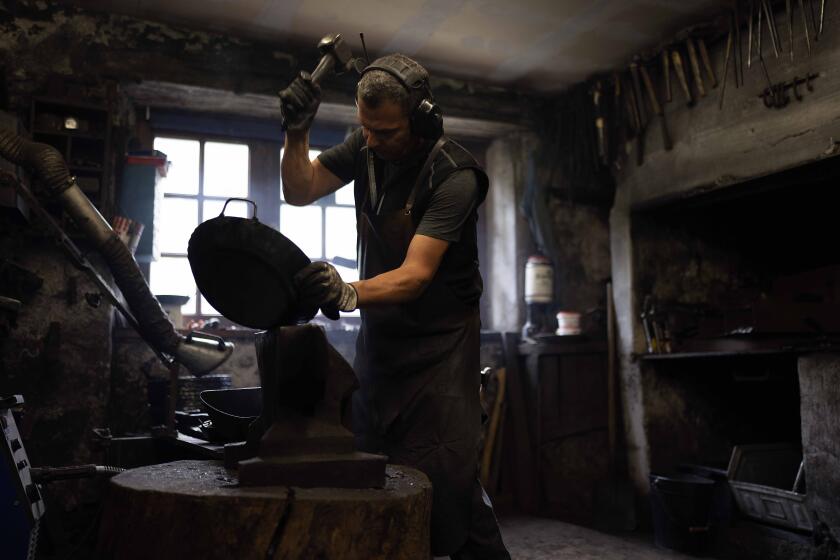 Hammersmith Andreas Rohrmoser works in his hammer forge, in Bad Oberdorf, Germany, Monday, Sept. 18, 2023. Rohrmoser has been forging thousands of wrought-iron pans the old-fashioned way in his centuries-old hammer mill in the Bavarian village of Bad Oberdorf near the Austria border.(AP Photo/Matthias Schrader)