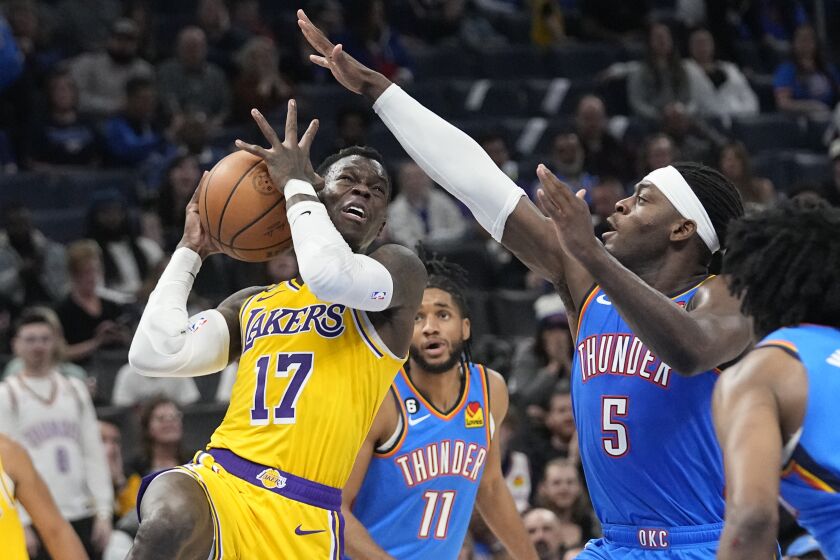Los Angeles Lakers guard Dennis Schroder (17) drives to the basket past Oklahoma City Thunder guard Luguentz Dort (5) in the second half of an NBA basketball game Wednesday, March 1, 2023, in Oklahoma City. (AP Photo/Sue Ogrocki)