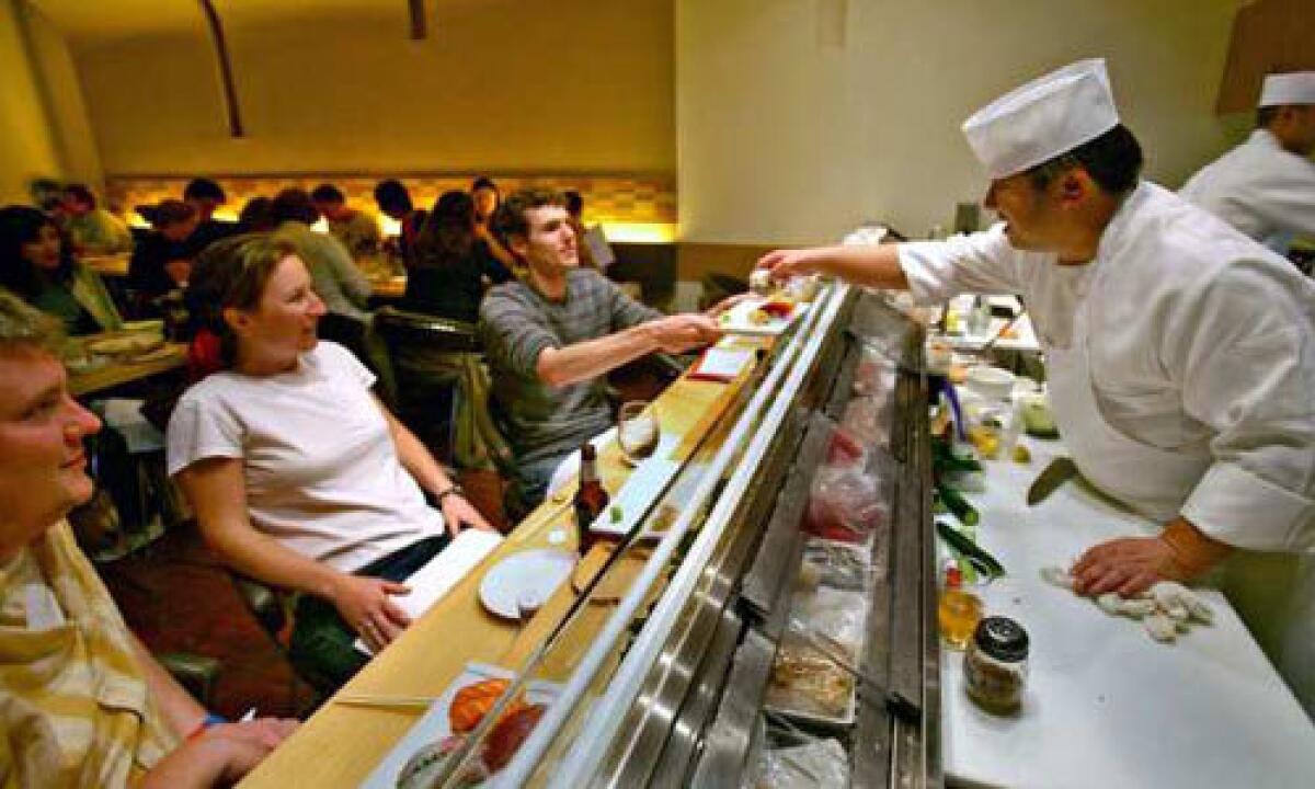 Sushi chef Sabu Hoshino serves diners at BiMi's sushi bar, the new sushi and izakaya restaurant on Wilshire Boulevard in Santa Monica.