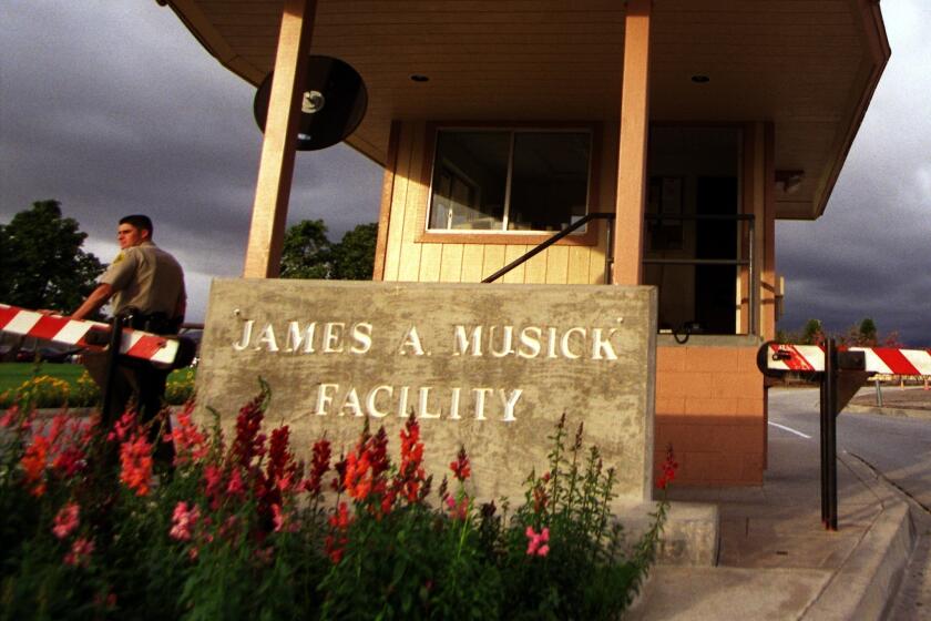 A guard stands at the front gate of the James A. Musick Facility in Irvine.